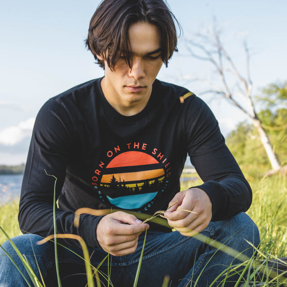 BORN ON THE SHIELD  SUNSET WITH CANADIAN SHIELD COLLECTIVE LOGO ON THE BACK (Unisex Long Sleeve Tee - black only)